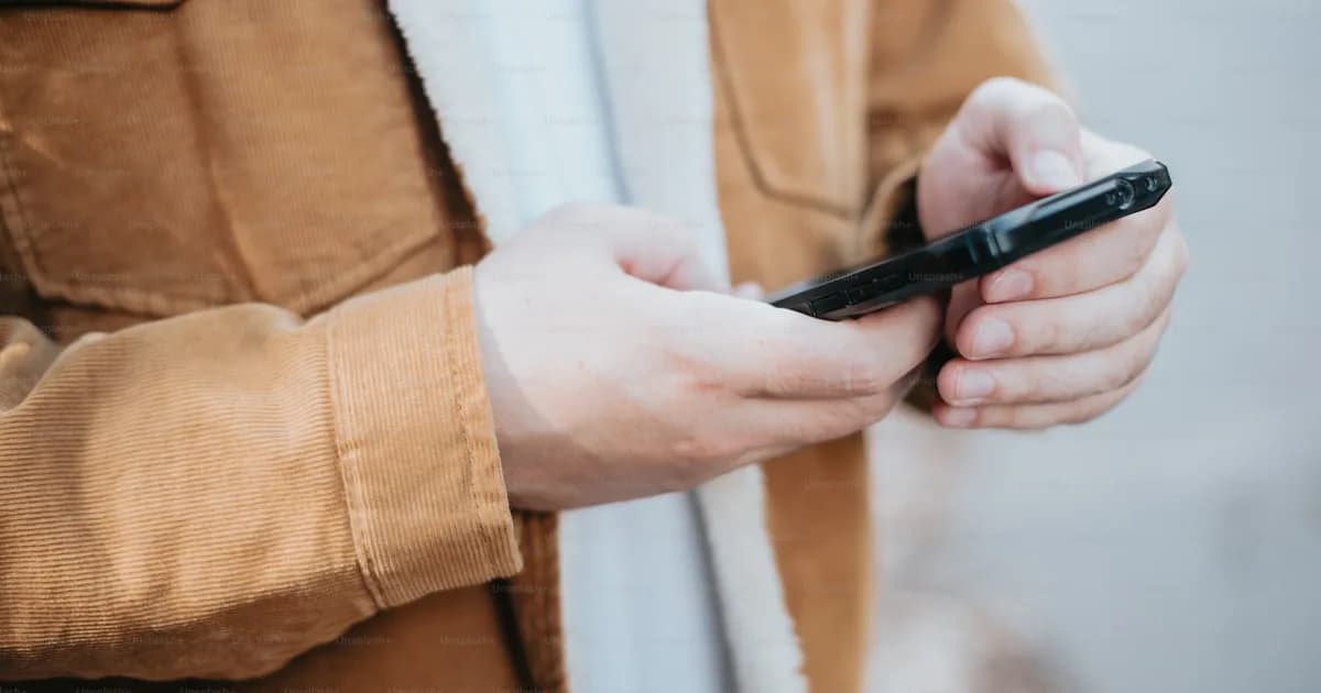 Közelkép egy kézben tartott mobiltelefonról